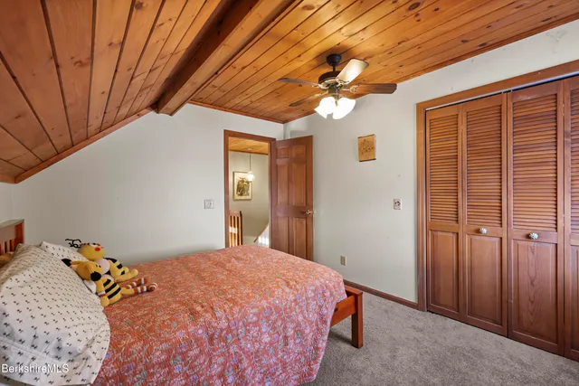 an empty room with windows and ceiling fan