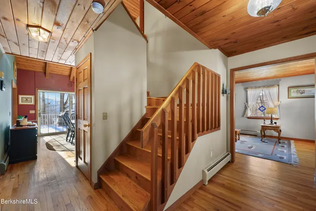a view of a hallway with wooden floor and staircase