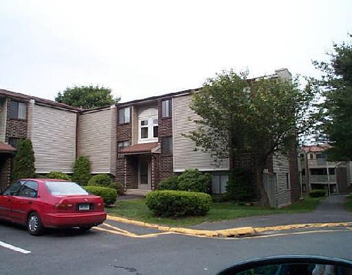 7 Padanaram Road, Unit E129 Danbury, CT 06811 - Photo 1 of 1 a front view of a house with a garden and yard