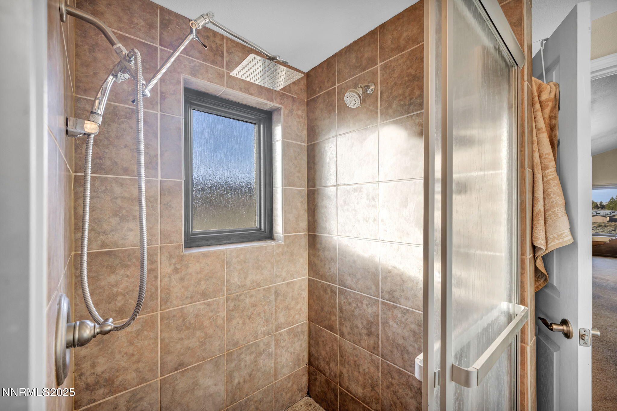 15034 North Red Rock Road Reno, NV 89508 - Photo 25 of 40 a bathroom with a glass shower door and mirror
