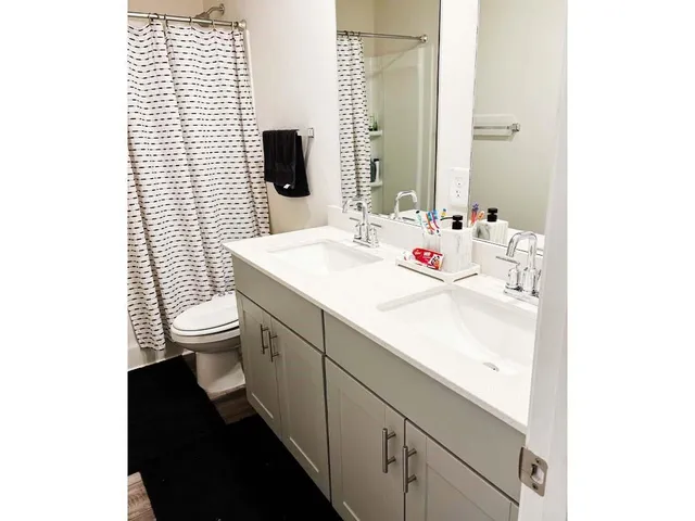 a bed sitting in a bedroom next to a window with wooden floor