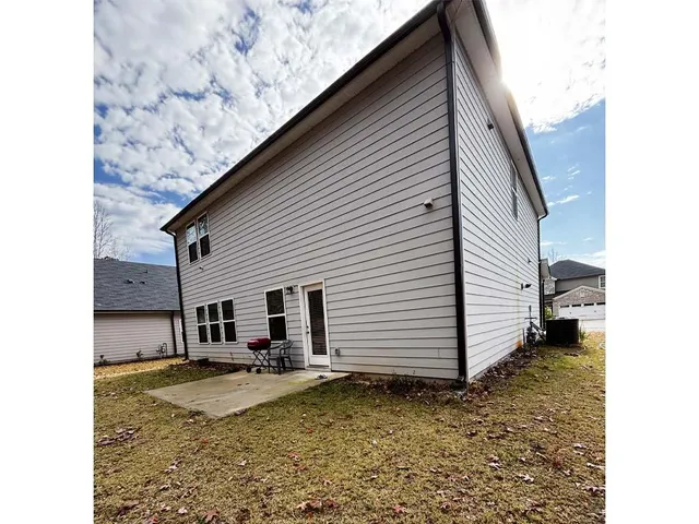 a view of a street with potted plants and large tree