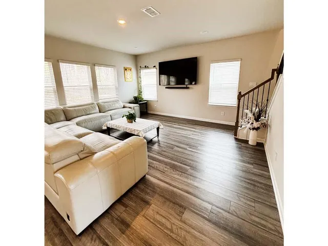 a living room with stainless steel appliances furniture and a kitchen view