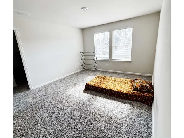 a bed sitting in a bedroom next to a window