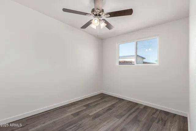 an empty room with a window and a fan
