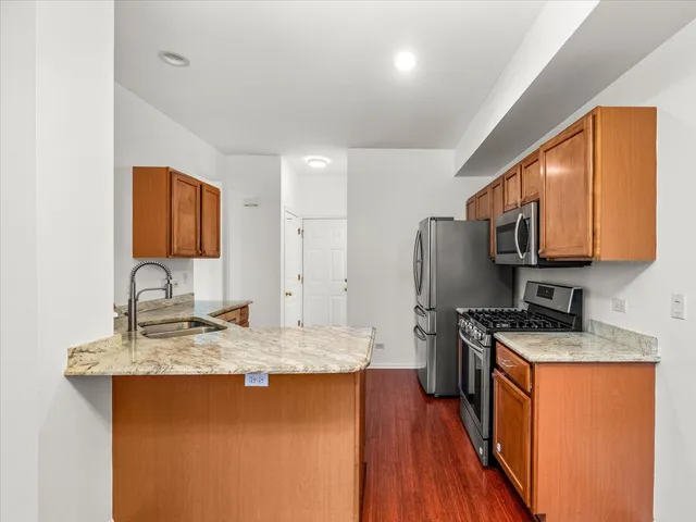 a kitchen with stainless steel appliances granite countertop a sink stove and refrigerator