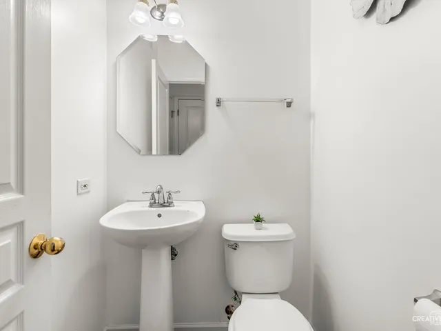 a bathroom with a sink toilet and mirror