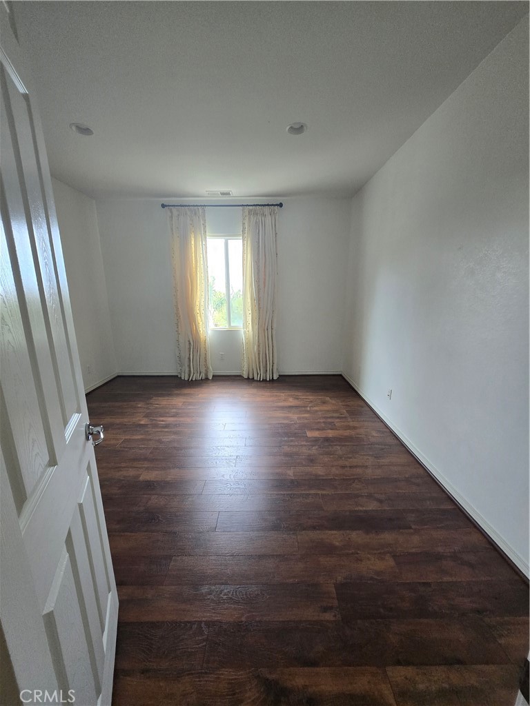 16231 Yarmouth Circle Riverside, CA 92503 - Photo 14 of 27 an empty room with wooden floor and windows