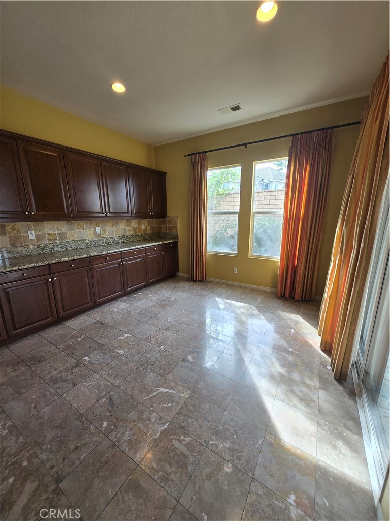 16231 Yarmouth Circle Riverside, CA 92503 - Photo 17 of 27 a view of an empty room with a window and a kitchen