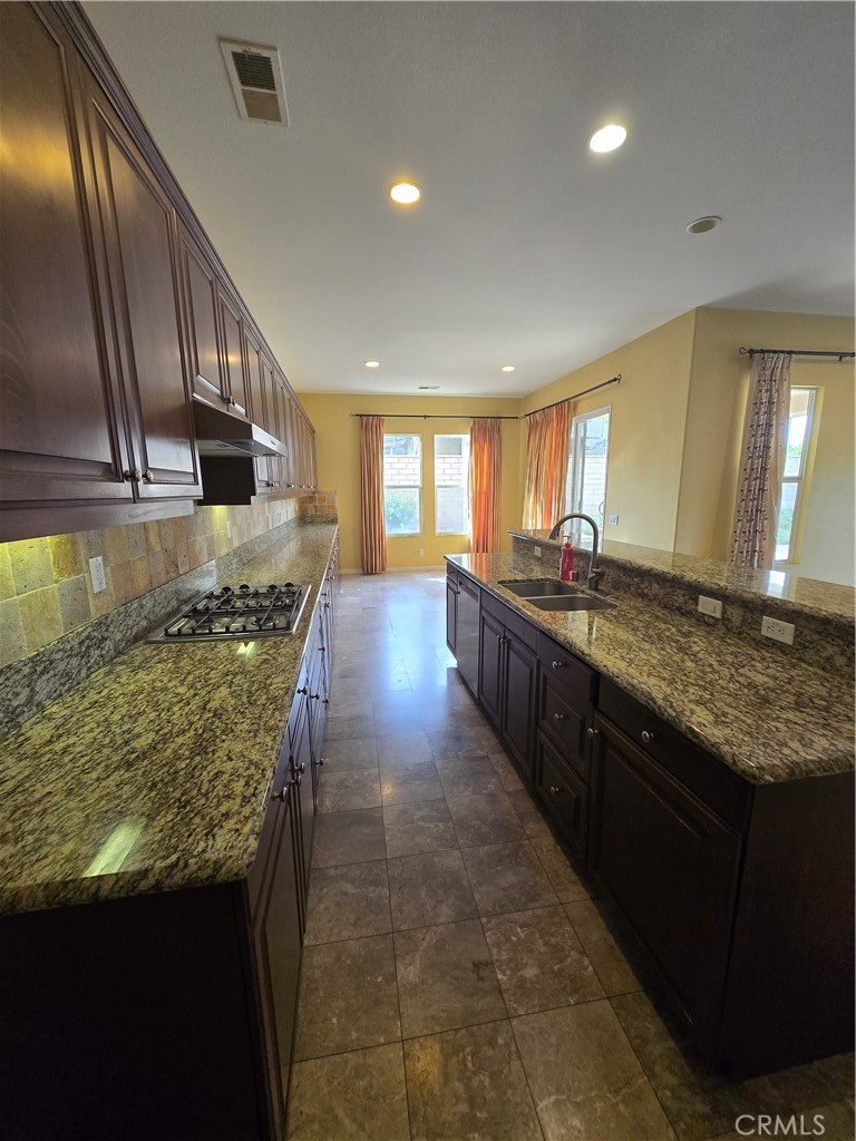 16231 Yarmouth Circle Riverside, CA 92503 - Photo 6 of 27 a large kitchen with granite countertop a sink and a stove