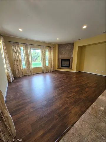 an empty room with wooden floor and fireplace