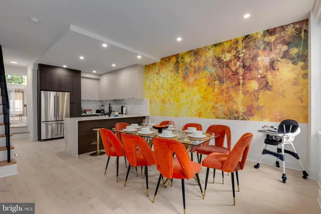 a kitchen with stainless steel appliances kitchen island granite countertop a dining table and chairs