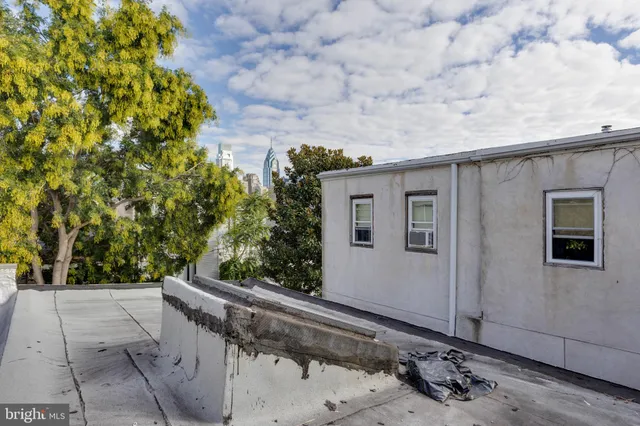 a front view of a house with a tree