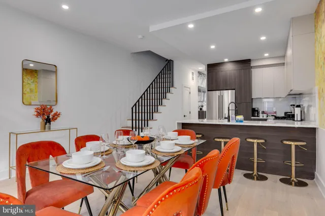a dining room with stainless steel appliances a table and chairs