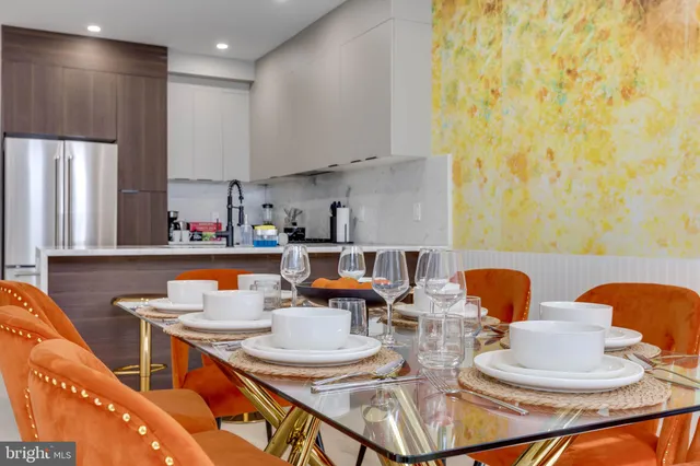 a kitchen with stainless steel appliances kitchen island granite countertop a table and chairs