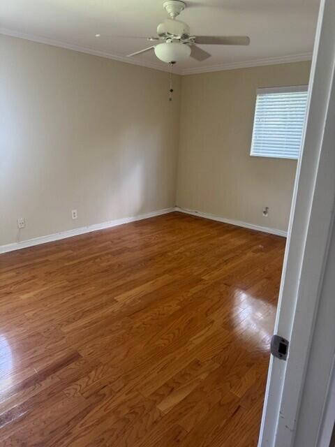 1915 Arabian Road West Lake Clarke Shores, FL 33406 - Photo 12 of 18 an empty room with wooden floor fan and window