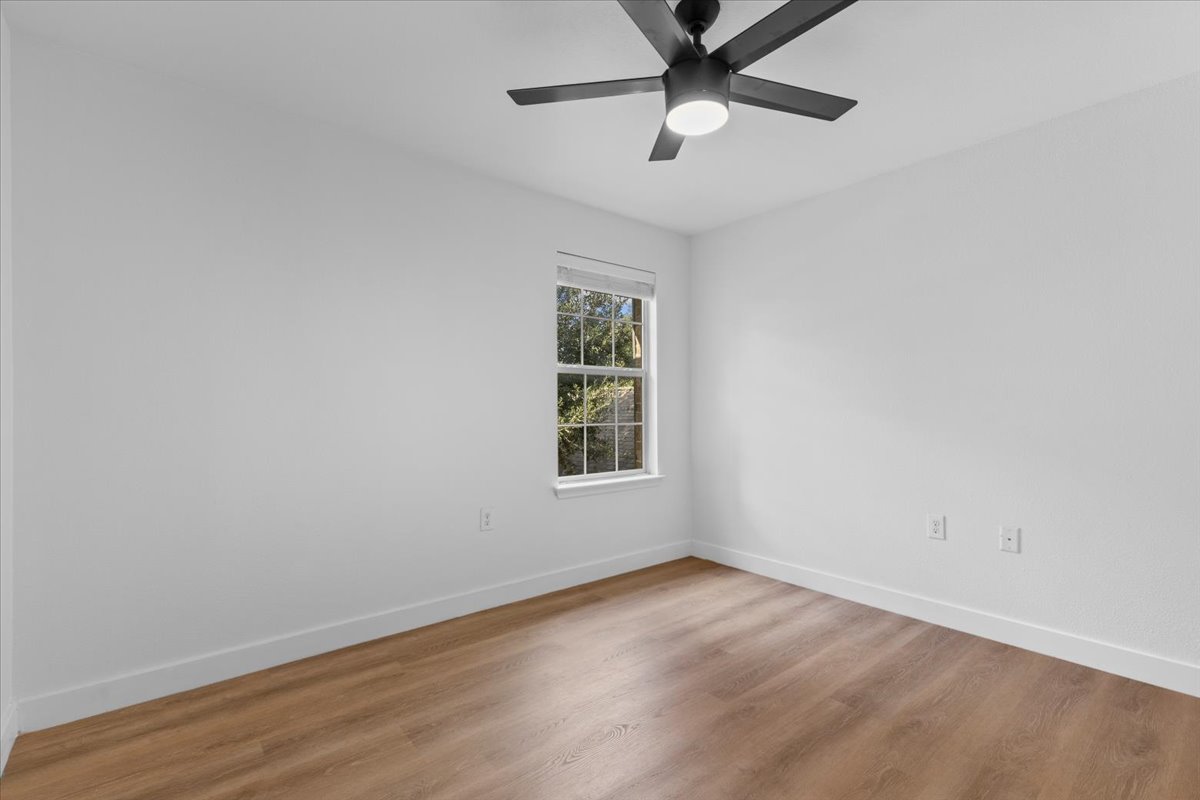 5940 Silver Screen Drive Austin, TX 78747 - Photo 11 of 17 Spare room with recently installed flooring and fan