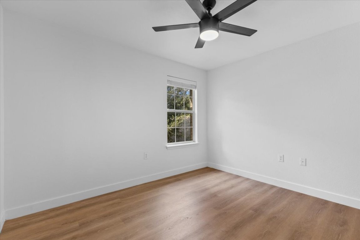 5940 Silver Screen Drive Austin, TX 78747 - Photo 11 of 17 an empty room with wooden floor and windows