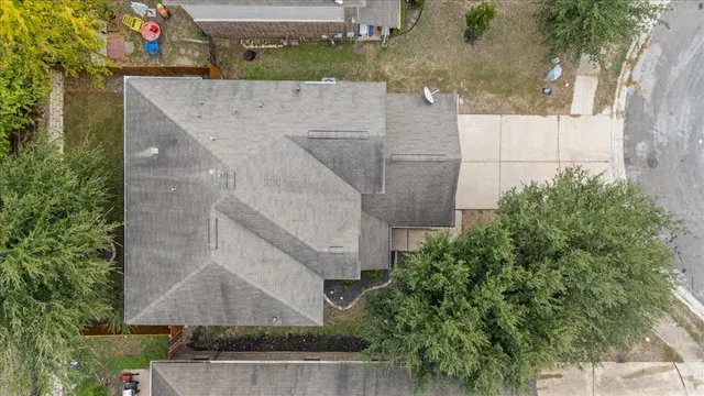 an aerial view of a house with a yard and large trees