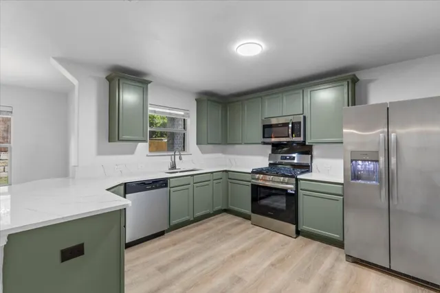 a kitchen with cabinets a sink and stainless steel appliances