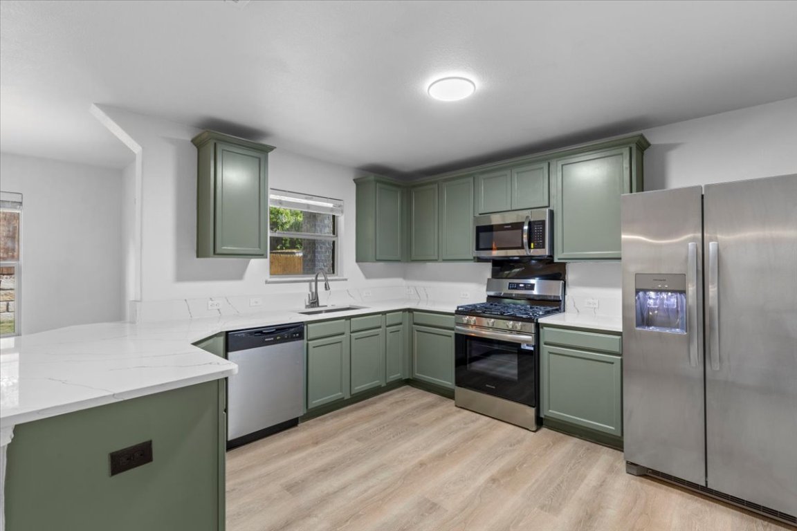 5940 Silver Screen Drive Austin, TX 78747 - Photo 2 of 17 a kitchen with cabinets a sink and stainless steel appliances