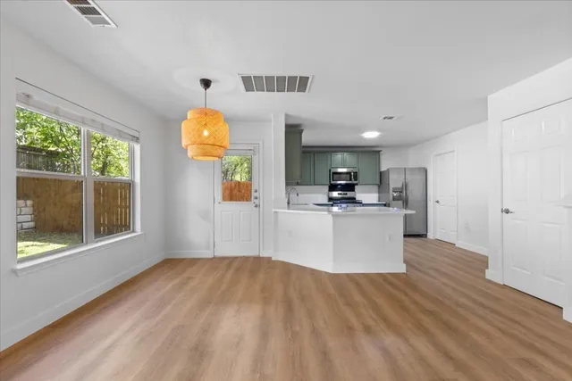 a view of kitchen with wooden floor and electronic appliances