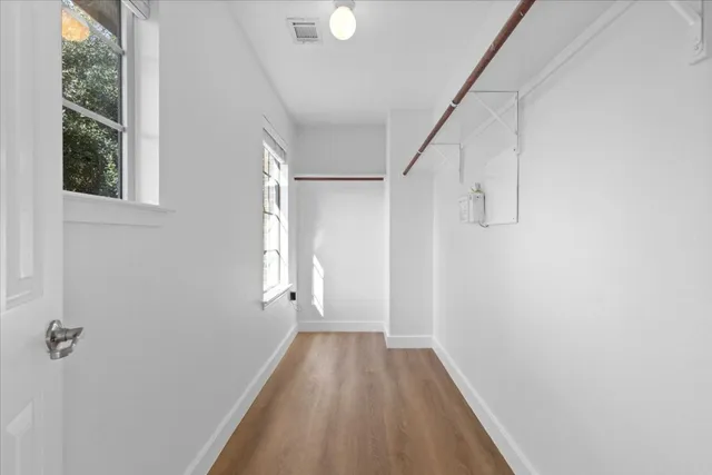 a view of a hallway with wooden floor and staircase