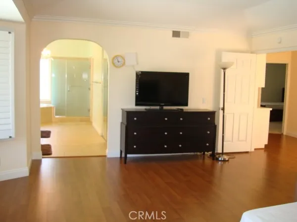 a living room with hard wood floors and a flat screen tv