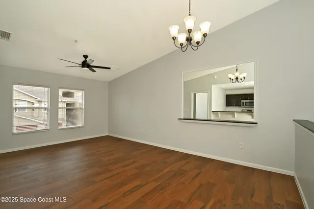 a view of a room with wooden floor and ceiling fan