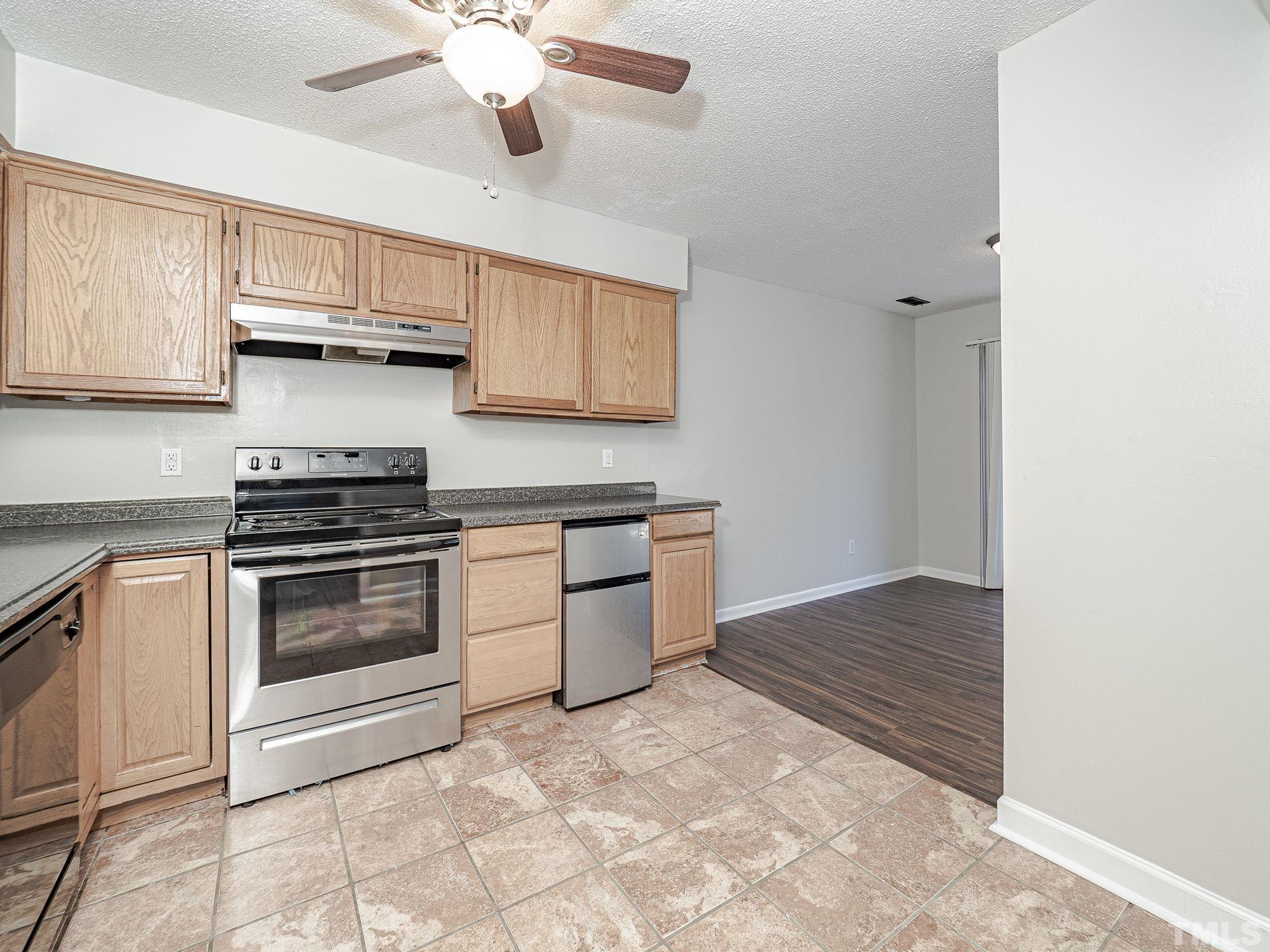 4705 Walden Pond Drive, Unit D Raleigh, NC 27604 - Photo 11 of 24 a kitchen with granite countertop a stove cabinets and stainless steel appliances