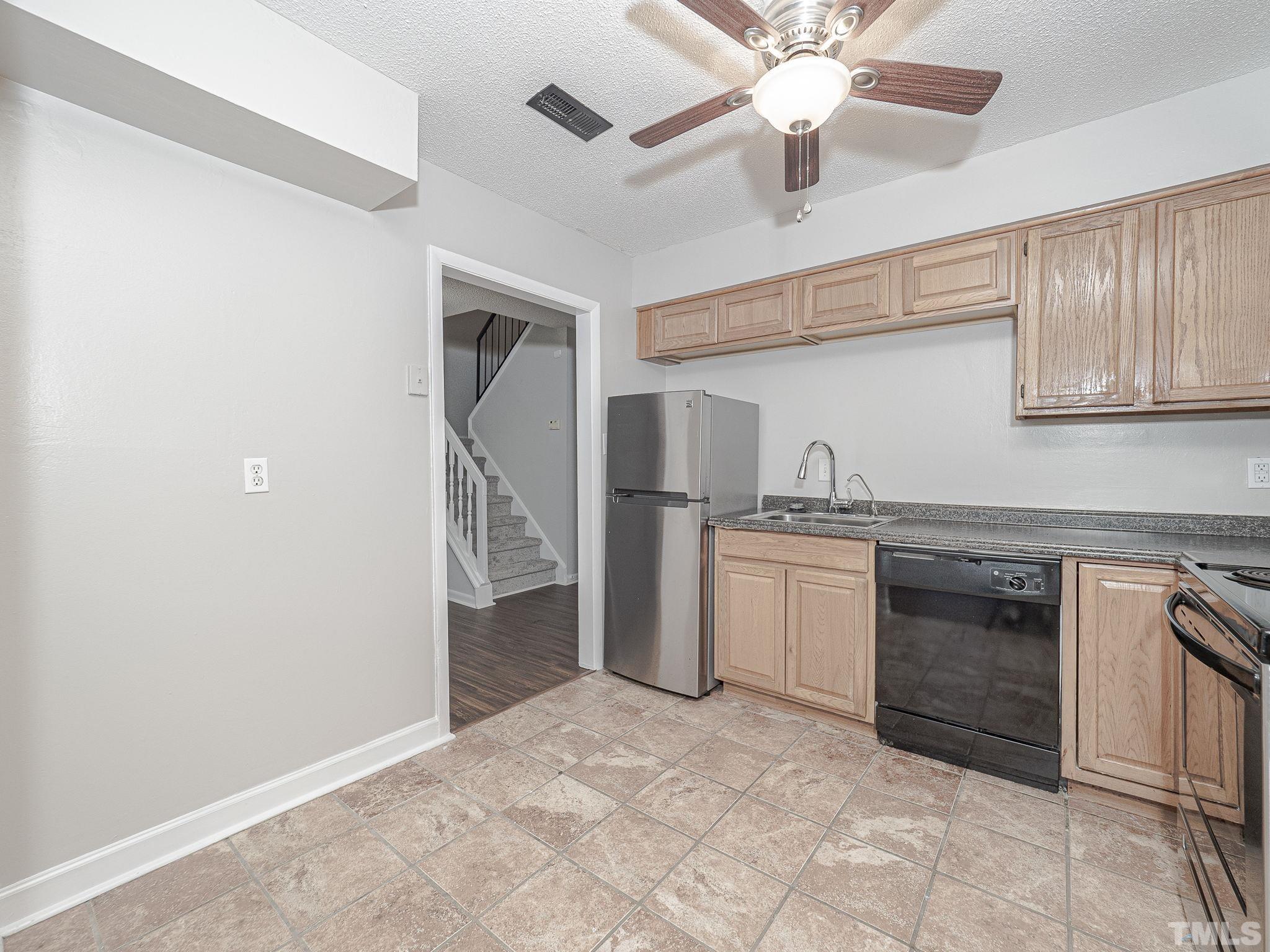 4705 Walden Pond Drive, Unit D Raleigh, NC 27604 - Photo 12 of 24 a kitchen with granite countertop a sink stainless steel appliances and cabinets