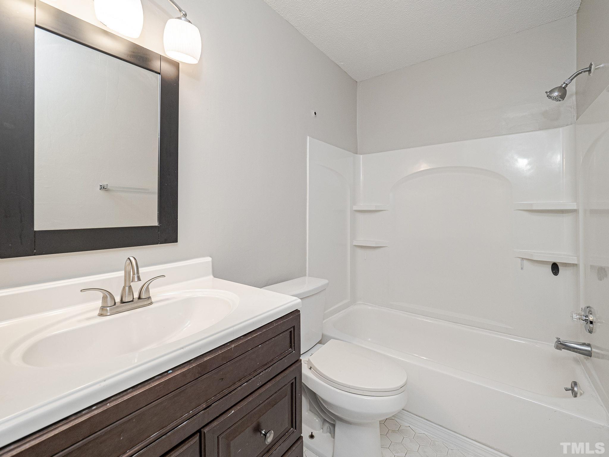 4705 Walden Pond Drive, Unit D Raleigh, NC 27604 - Photo 17 of 24 a bathroom with a sink a toilet and a mirror