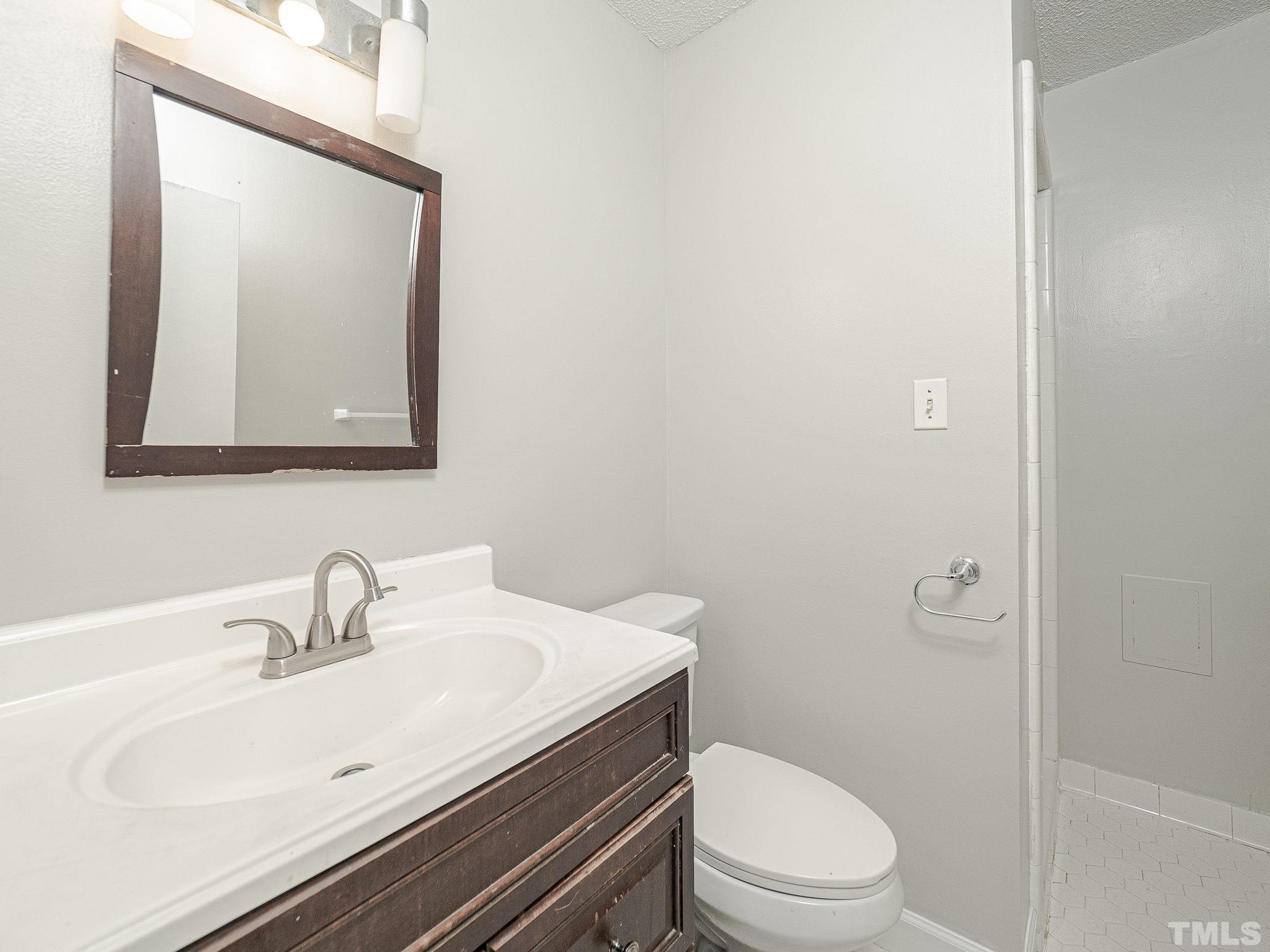4705 Walden Pond Drive, Unit D Raleigh, NC 27604 - Photo 20 of 24 a bathroom with a sink a toilet and mirror