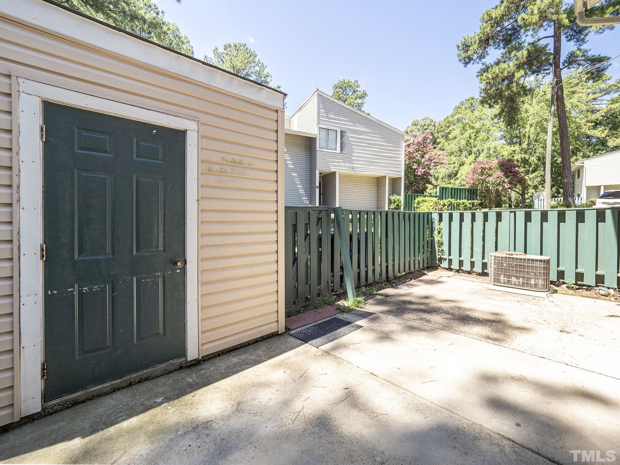 4705 Walden Pond Drive, Unit D Raleigh, NC 27604 - Photo 21 of 24 a view of a house with a small yard and wooden fence