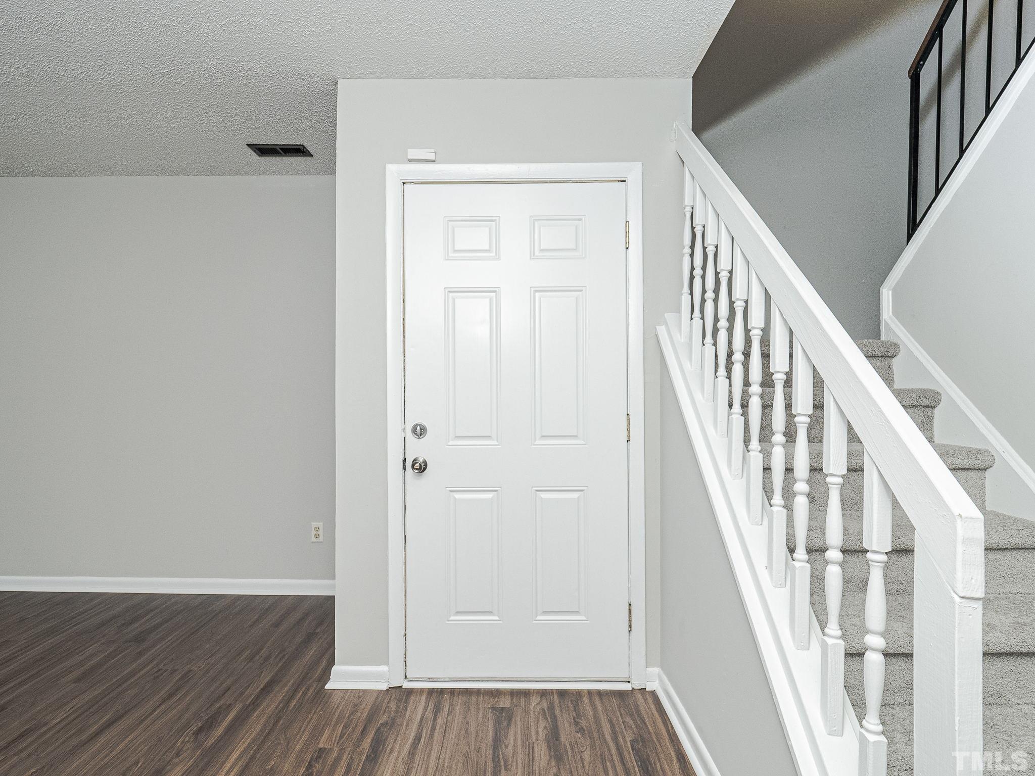 4705 Walden Pond Drive, Unit D Raleigh, NC 27604 - Photo 4 of 24 an entryway with wooden floor and stairs