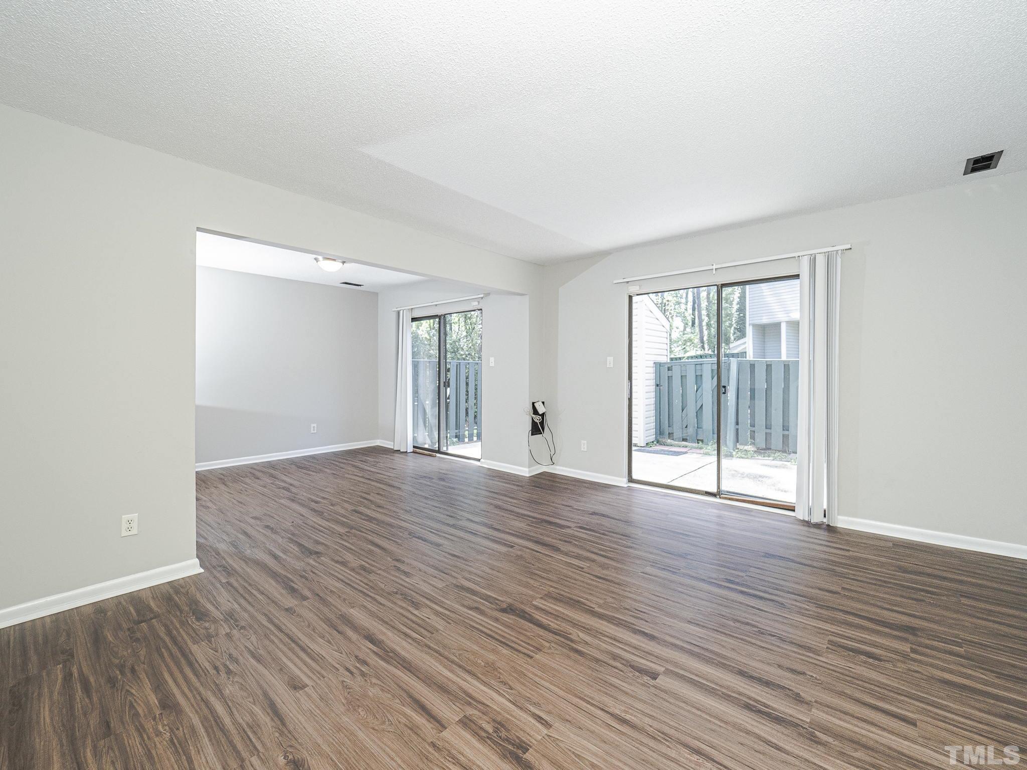 4705 Walden Pond Drive, Unit D Raleigh, NC 27604 - Photo 5 of 24 a view of an empty room with wooden floor and a window