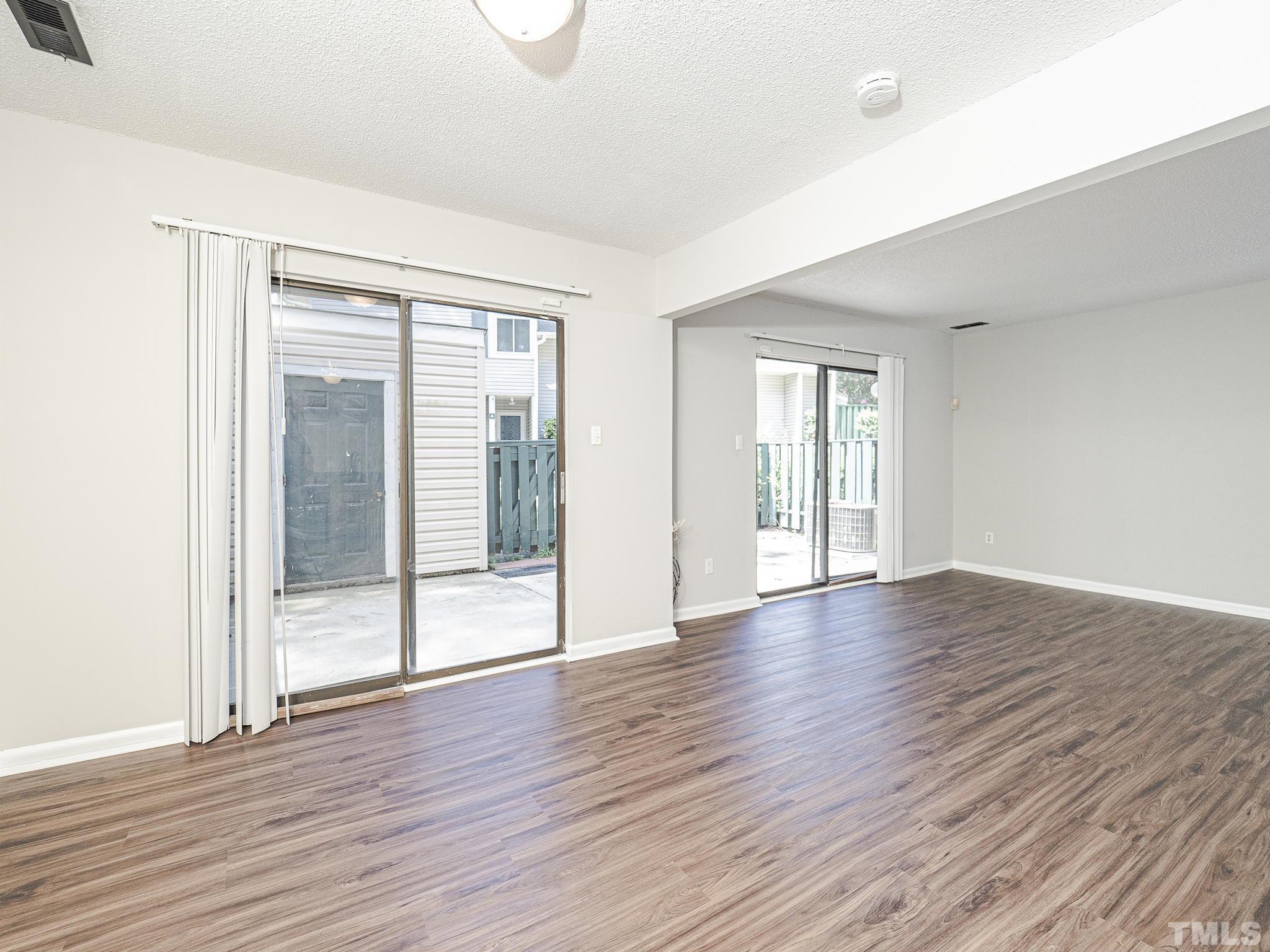 4705 Walden Pond Drive, Unit D Raleigh, NC 27604 - Photo 7 of 24 an empty room with wooden floor and windows