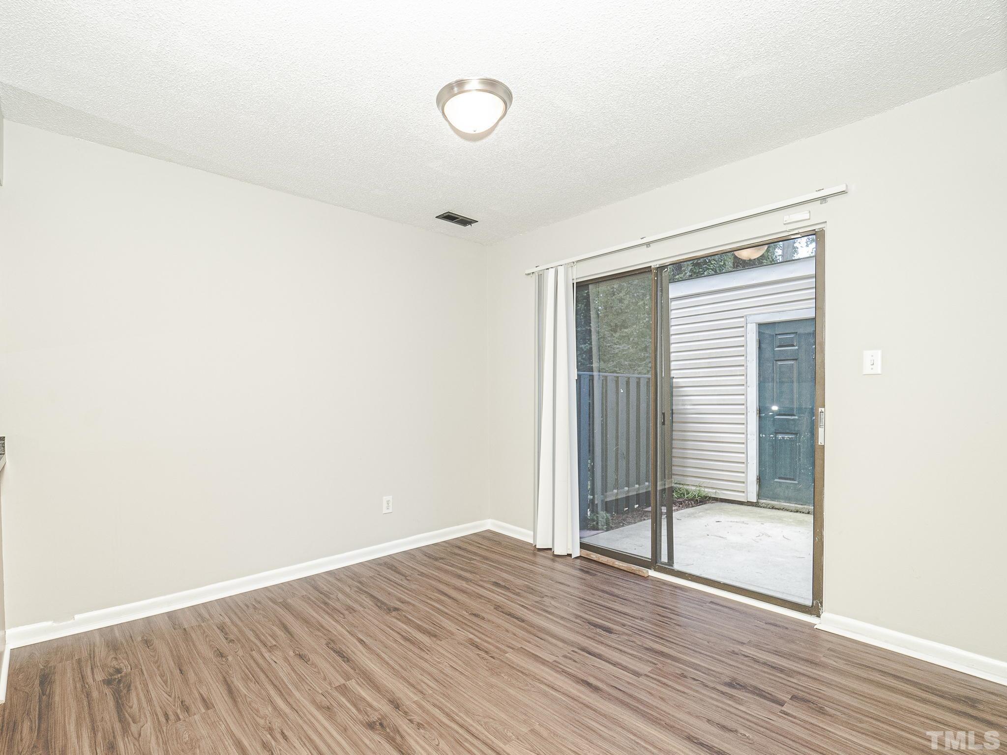4705 Walden Pond Drive, Unit D Raleigh, NC 27604 - Photo 9 of 24 a view of an empty room with wooden floor and a window