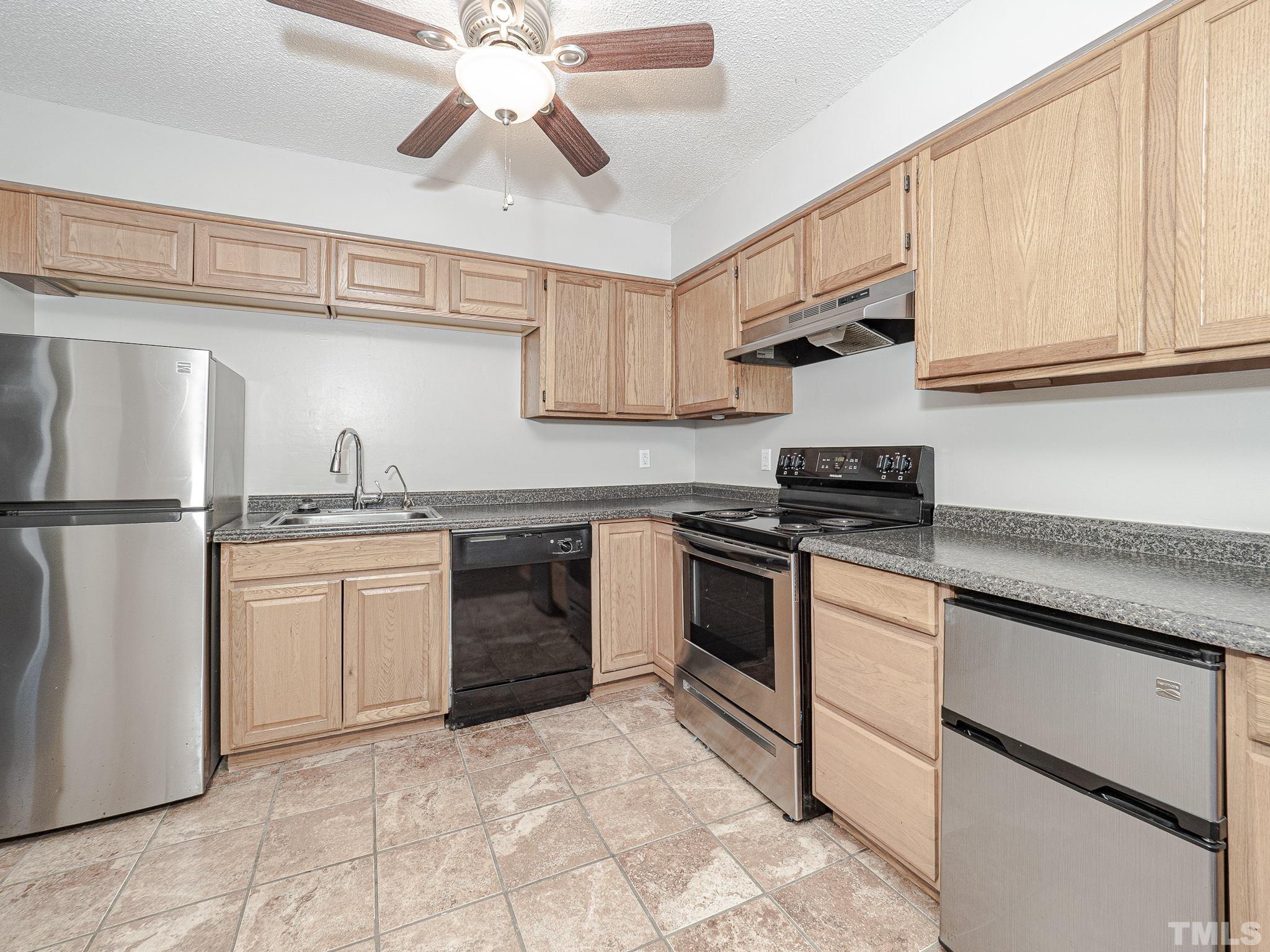 4705 Walden Pond Drive, Unit D Raleigh, NC 27604 - Photo 10 of 24 a kitchen with a stove cabinets and a refrigerator