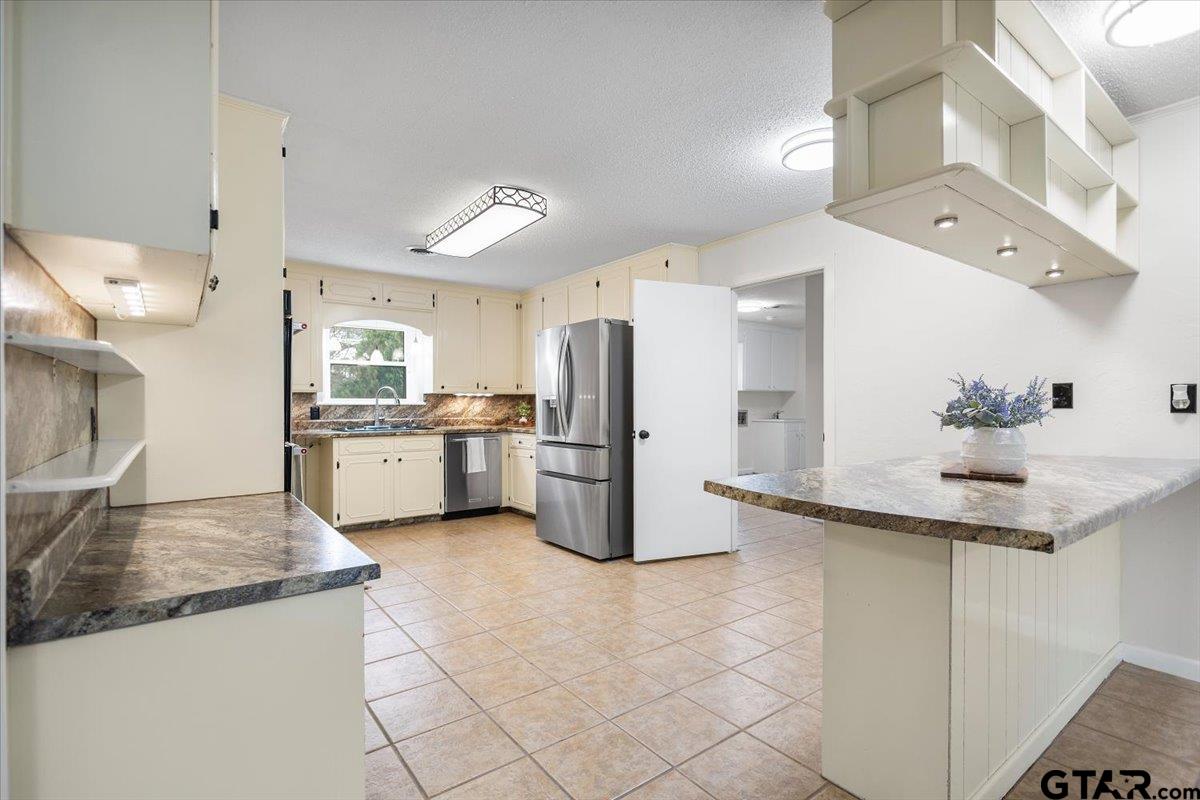 2320 Grangeway Road Marshall, TX 75672 - Photo 14 of 48 a kitchen with stainless steel appliances granite countertop a sink and a refrigerator