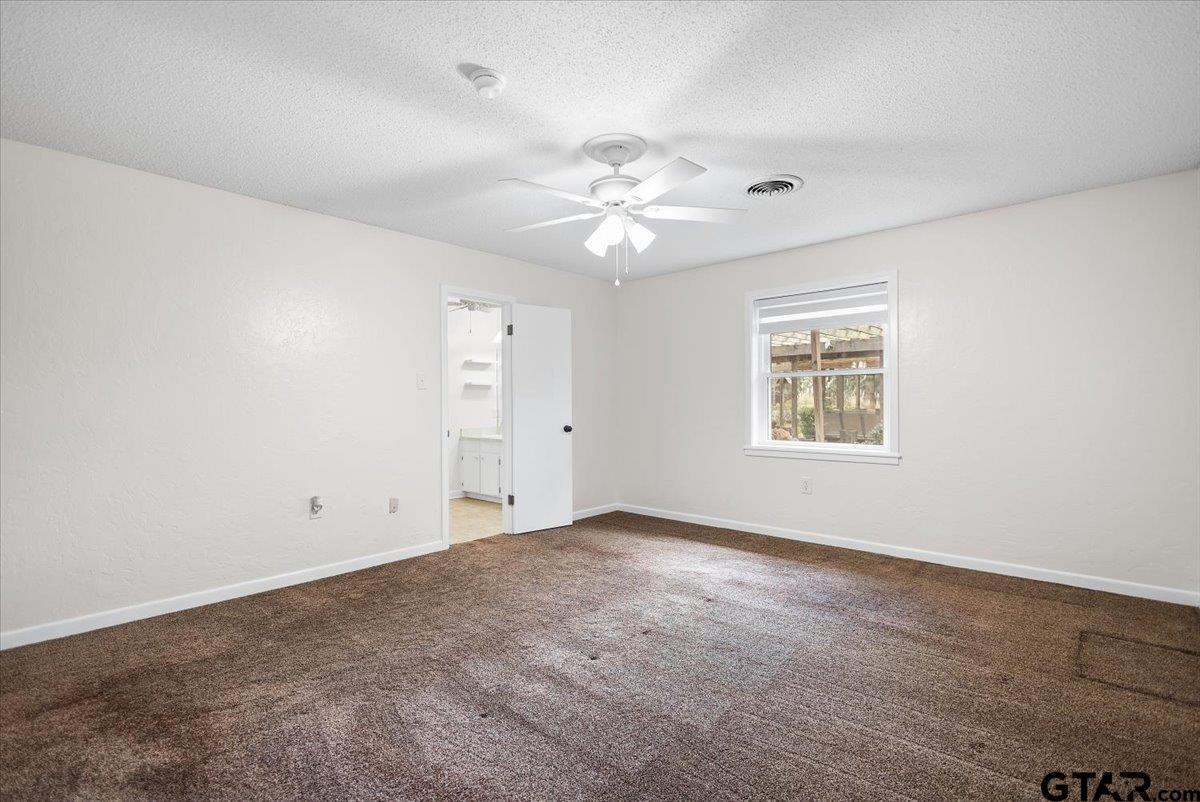 2320 Grangeway Road Marshall, TX 75672 - Photo 22 of 48 an empty room with a window and a fan