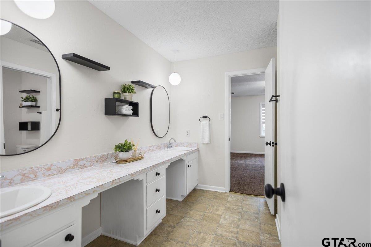 2320 Grangeway Road Marshall, TX 75672 - Photo 29 of 48 a bathroom with a double vanity sink and a mirror