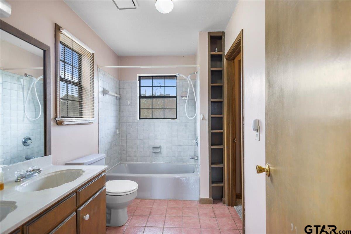 2320 Grangeway Road Marshall, TX 75672 - Photo 44 of 48 a bathroom with a granite countertop toilet a sink and a bathtub