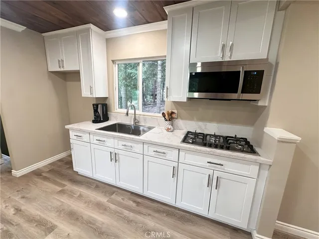 a kitchen with white cabinets and appliances