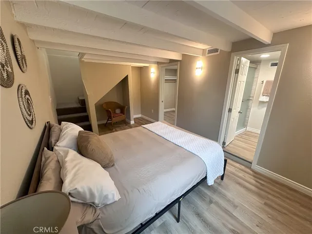 a spacious bedroom with a bed and a mirror