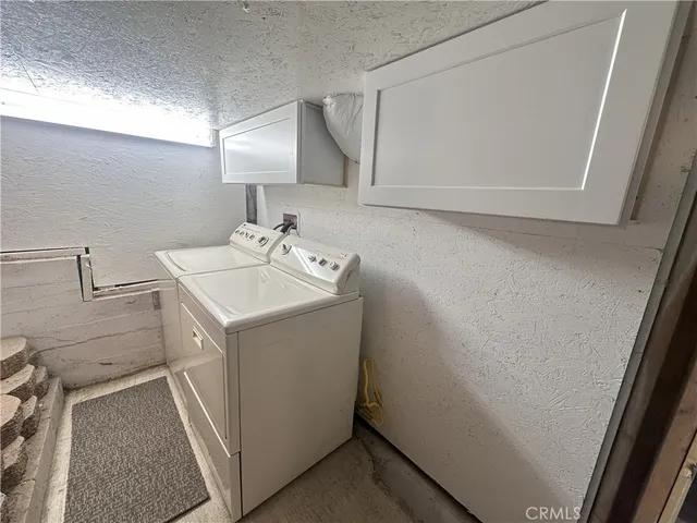 a utility room with cabinets washer and dryer