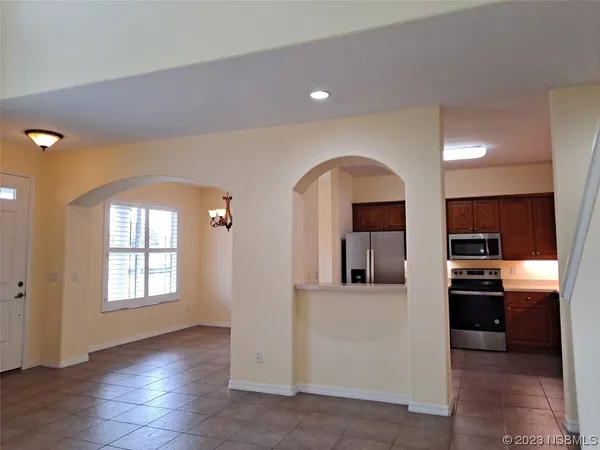 a view of a living room with kitchen area and wooden floor