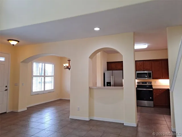 a view of a living room with kitchen area and wooden floor