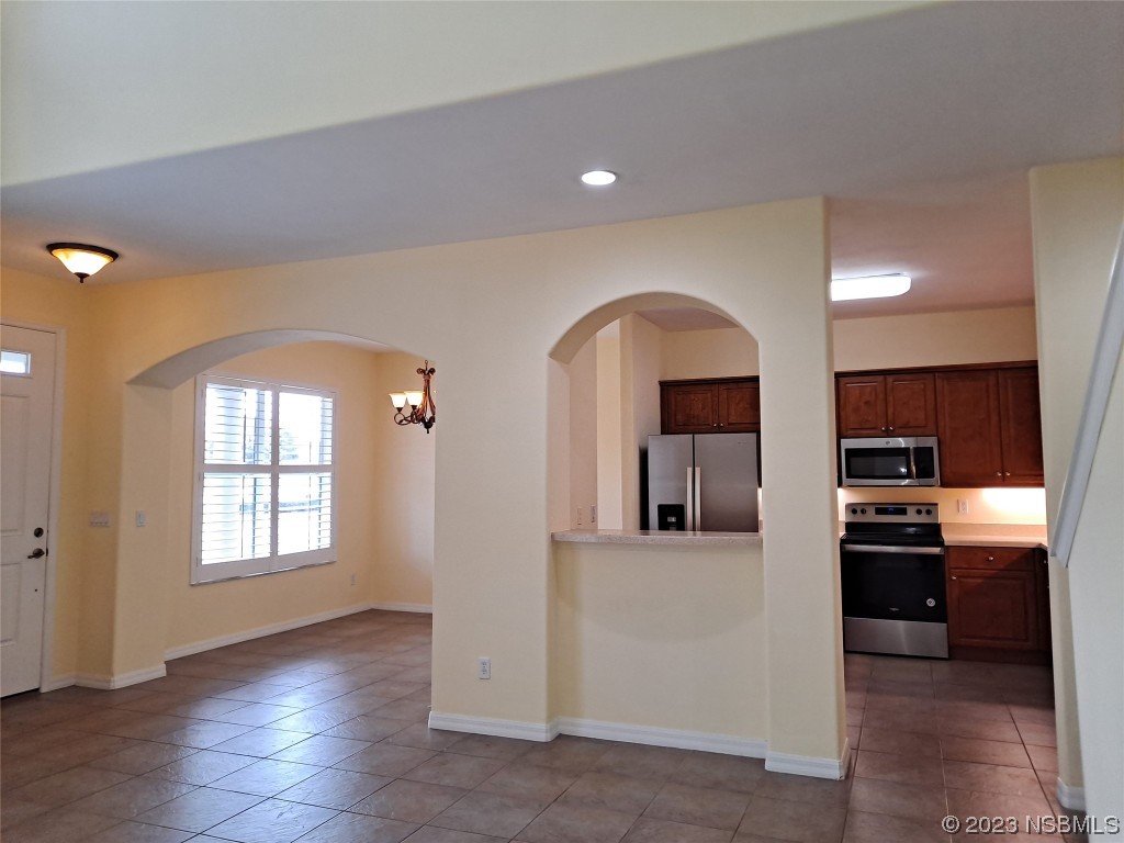 334 Airport Road New Smyrna Beach, FL 32168 - Photo 5 of 33 a view of a living room with kitchen area and wooden floor
