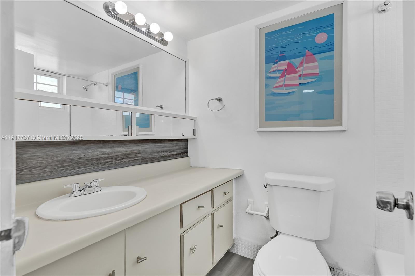 8000 Harding Avenue, Unit 7F Miami Beach, FL 33141 - Photo 14 of 46 a bathroom with a toilet a sink and mirror
